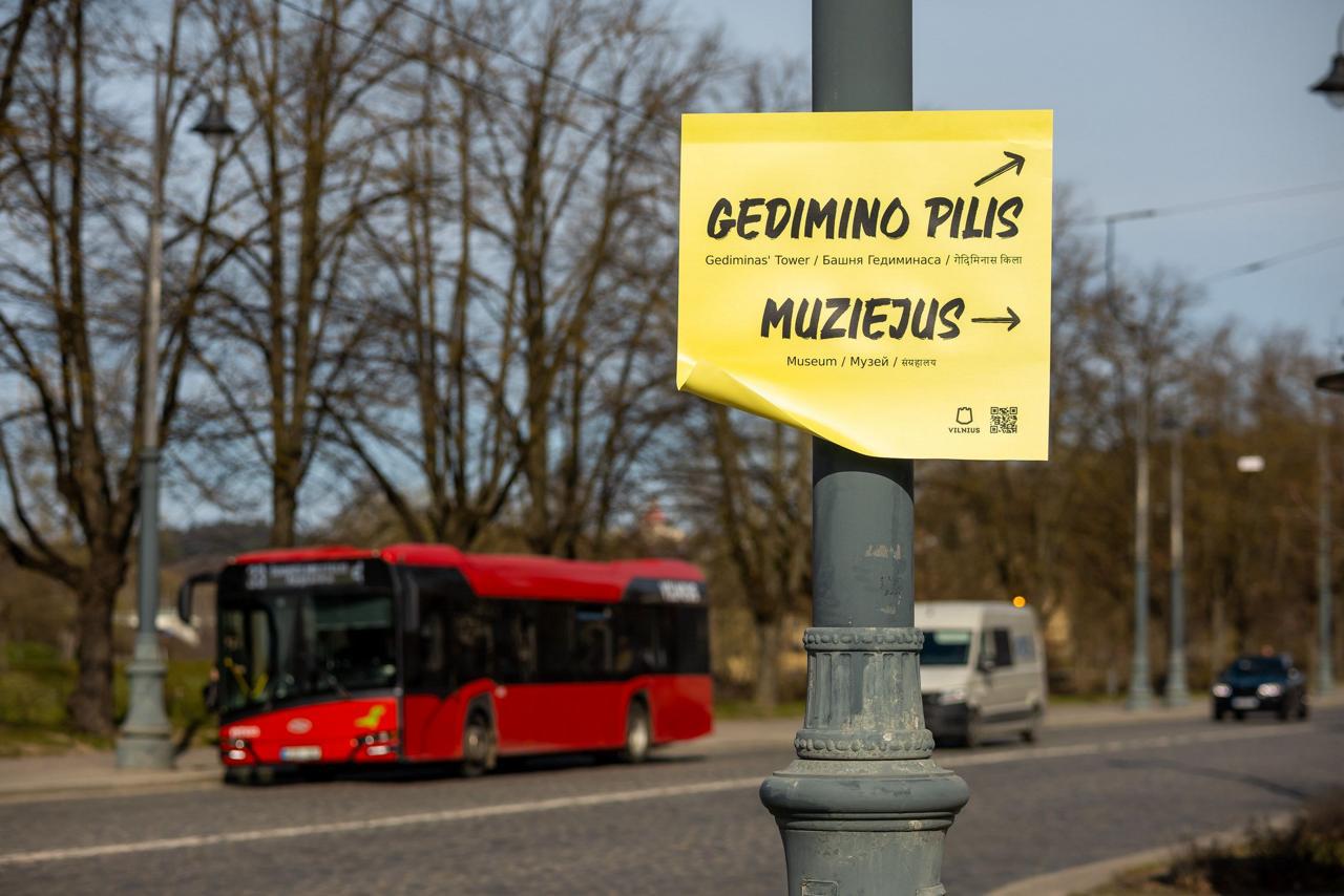 Жовтий стікер на ліхтарному стовпі у Вільнюсі: «GEDIMINO PILIS — Gediminas' Tower / Башня Гедиминаса»